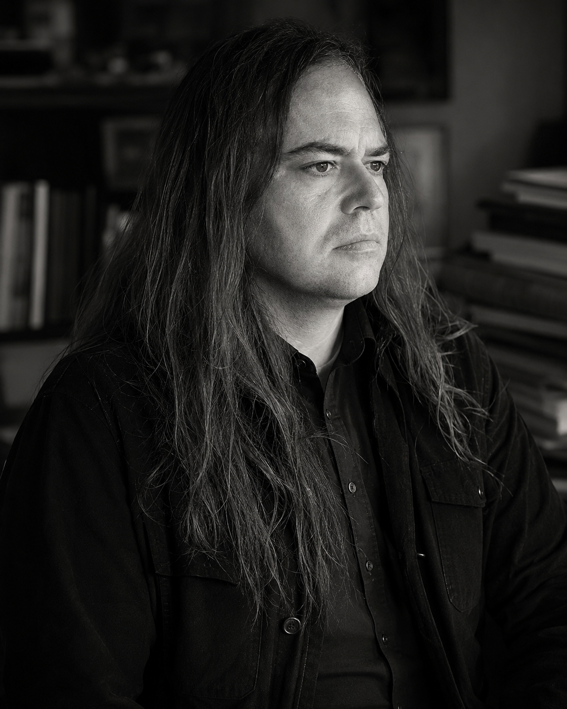 Ritratto di Michele Toscan in uno studio con libri e documenti.